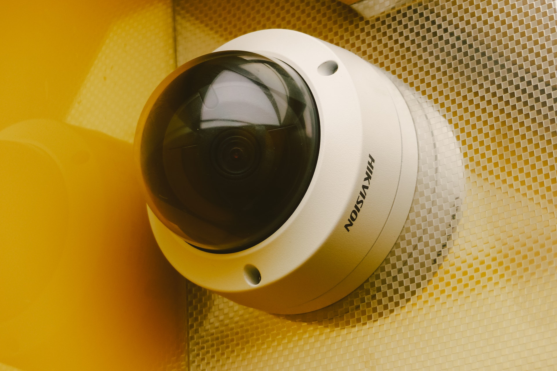 A small, round, discreet CCTV camera on a wall